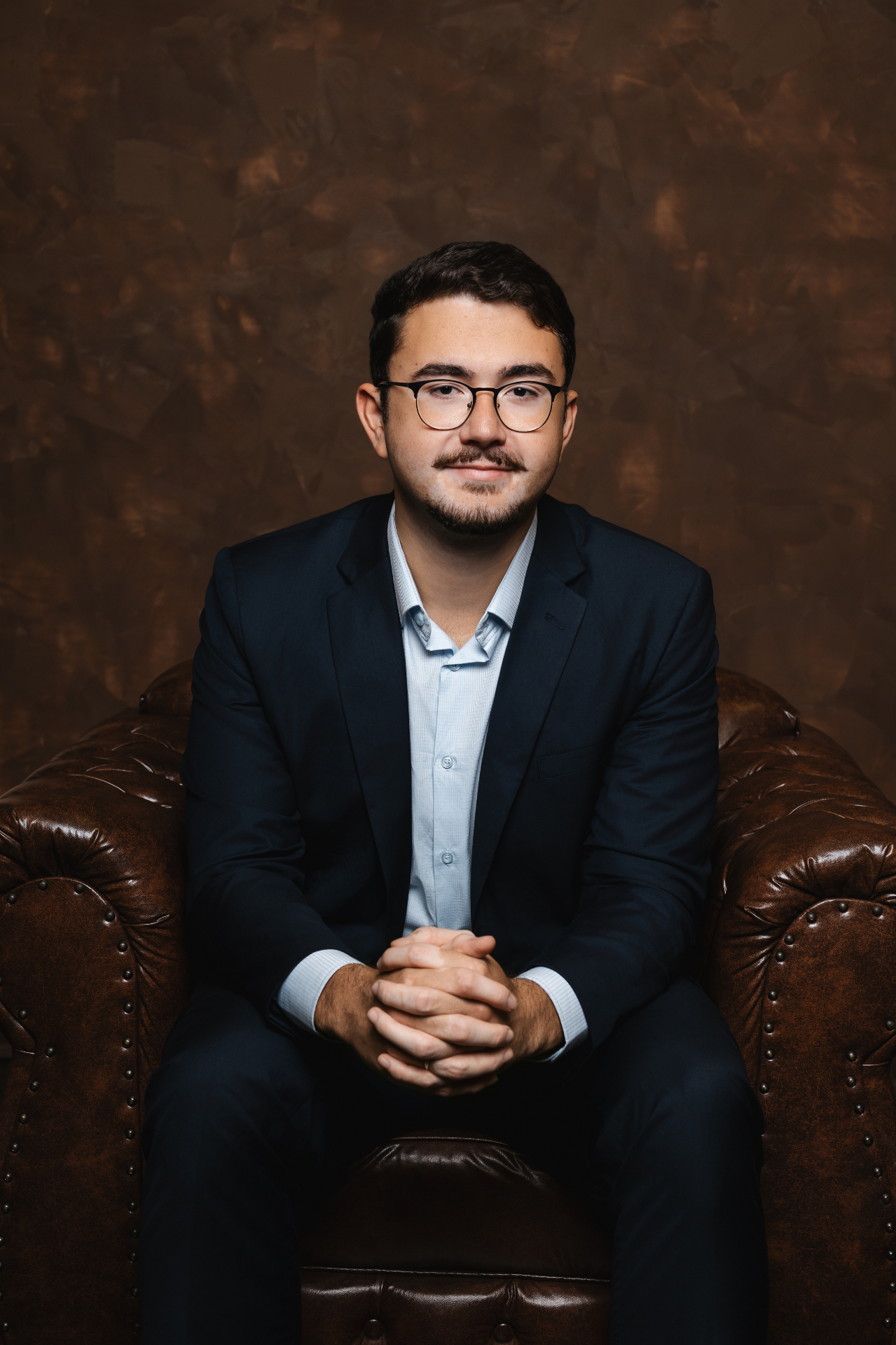 Gustavo Camillo sentado, de terno azul